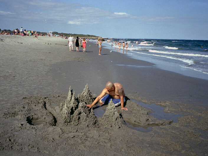 Man Building Sand Castles on Beach.